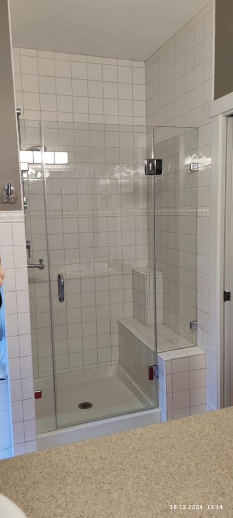 Glass shower with hinge door and inline panel installed by Coast Glass