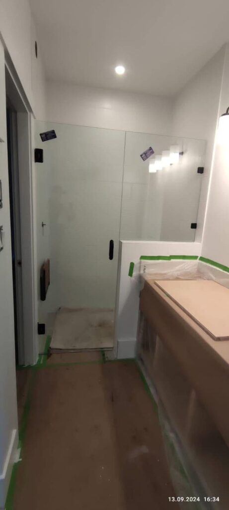 Glass shower with hinge door and inline panel installed by Coast Glass