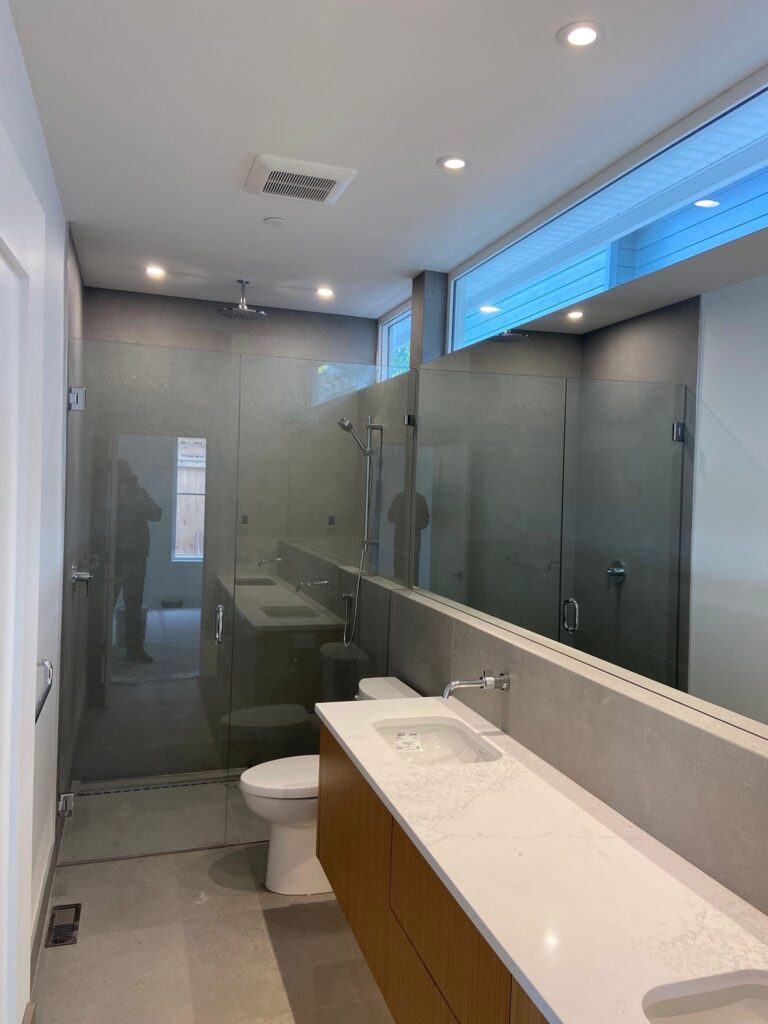 Glass shower with hinge door and inline panel installed by Coast Glass